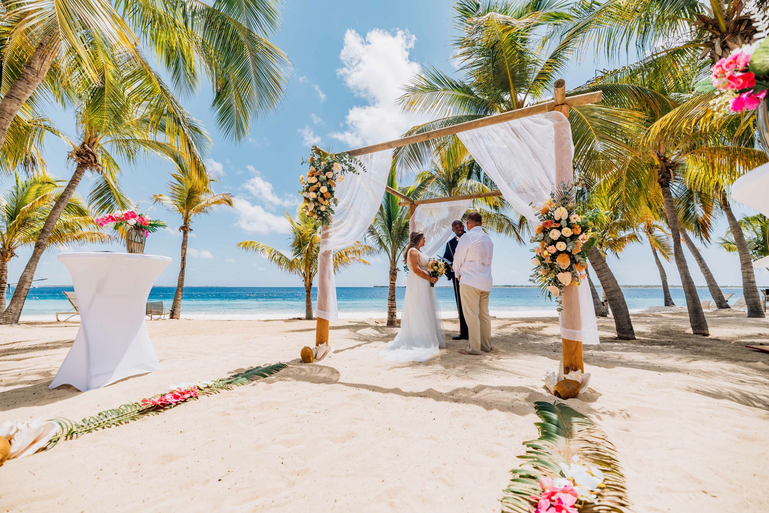 Intimate Bonaire beach wedding with guests seated under white parasols